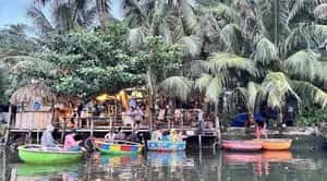 Tourists smiling during coconut boat Hoi An adventure with stunning river and palm tree views