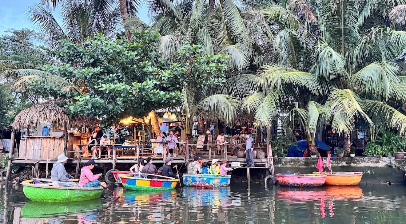 Tourists smiling during coconut boat Hoi An adventure with stunning river and palm tree views